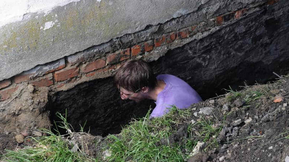 Man die een muur aan het onderkappen is.